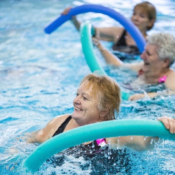 Seniors in a swimming pool with pool floats