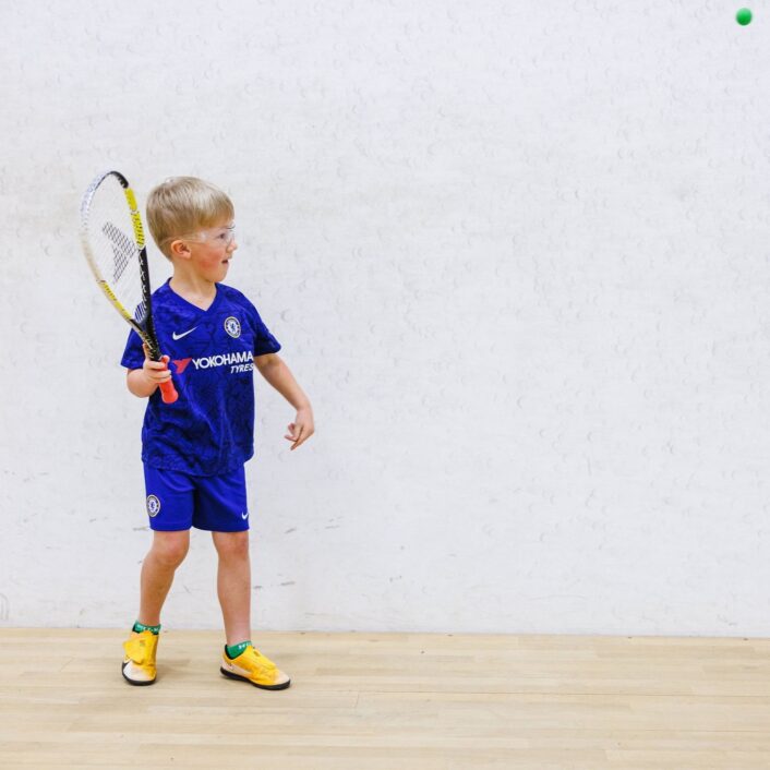 Child learning to play squash