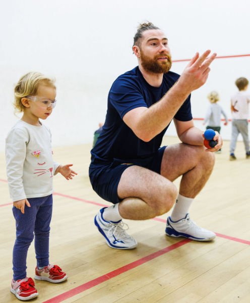 Kit teacking a kids squash lesson