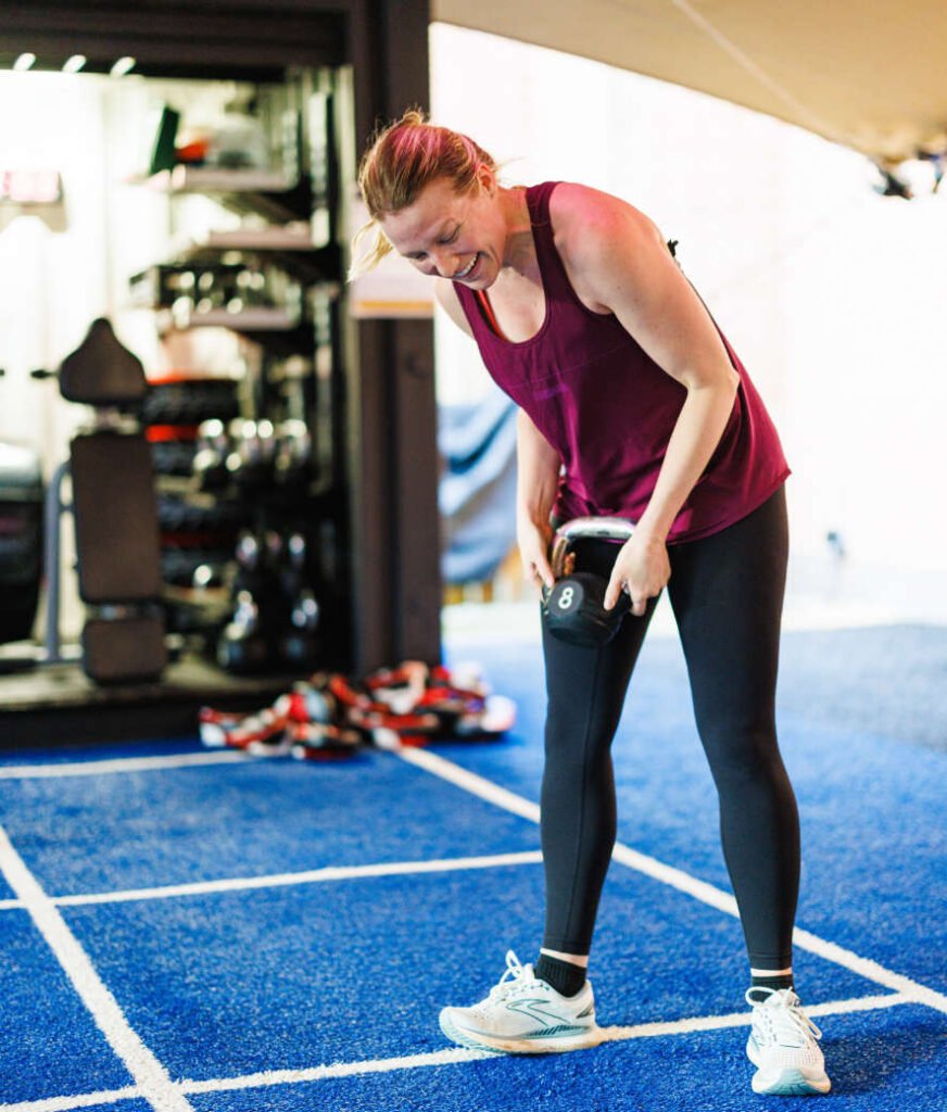 Woman using kettlebells at the outdoor fitness yard