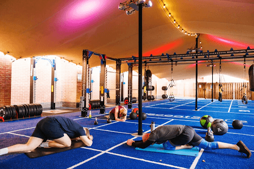 group exercise class in outdoor gym with marquee roof