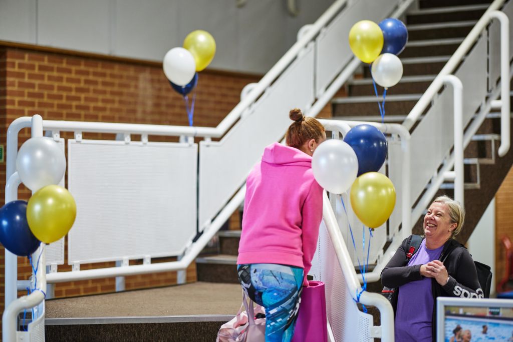 Two people on the stairs at Bluecoat Sports talking