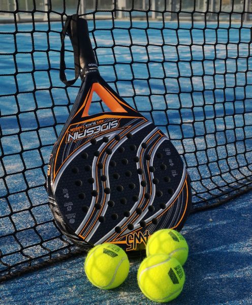 Padel racket and balls on a court