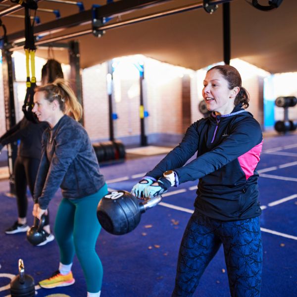 two women swimming kettlebells in an exercise class