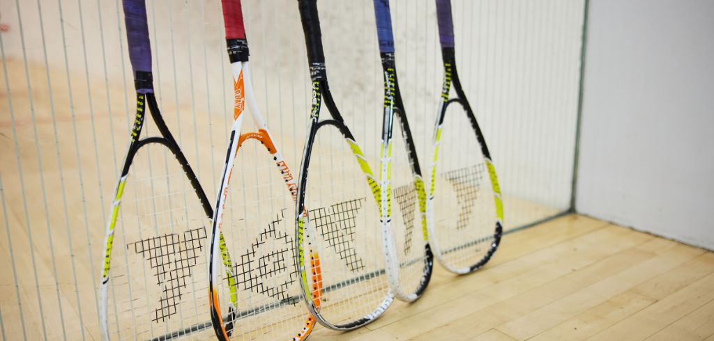 four squash rackets against a wall