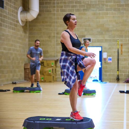 A woman doing a step aerobics class