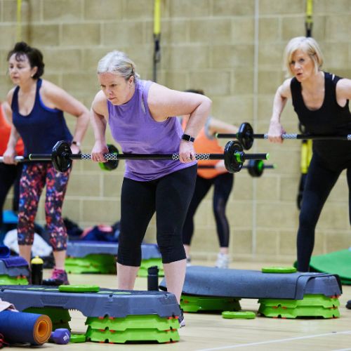 Three women doing a body pump class