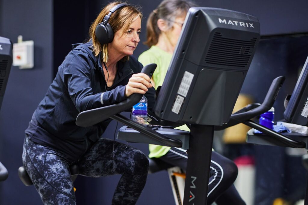 Woman using a cycling machine with headphones
