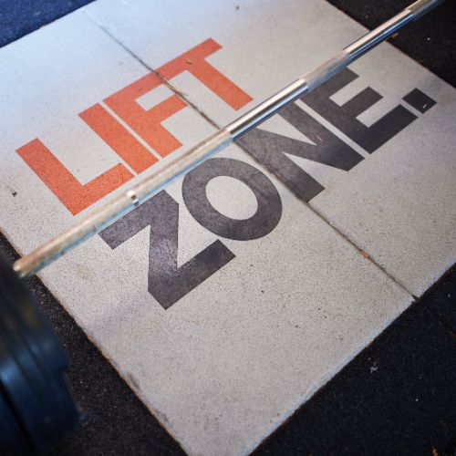 Lift zone written on the floor with a barbell weight