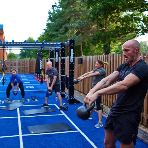 Group of people doing kettlebell swings in the Fitness Yard at Bluecoat Sports