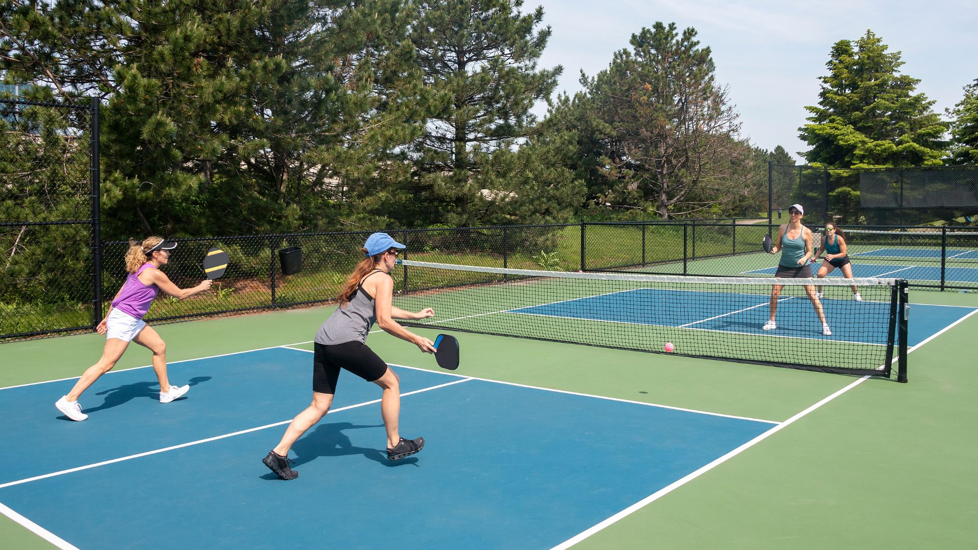 Women playing pickleball outdoors