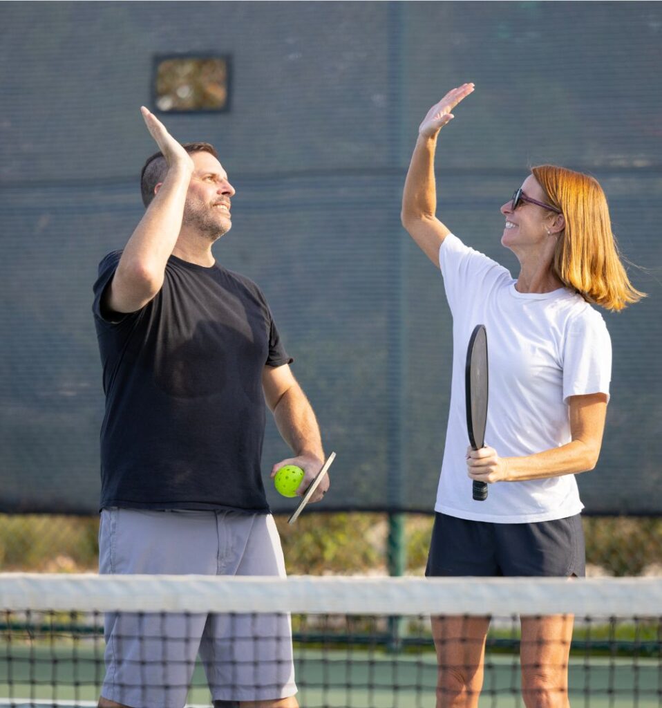 man and woman high-five in pickleball game