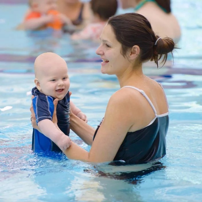 parent with baby in swimming pool