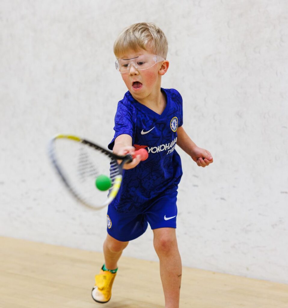 young boy playing squash