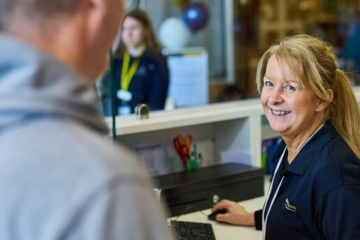 Bluecoat Sports reception staff member interacting with customer smiling