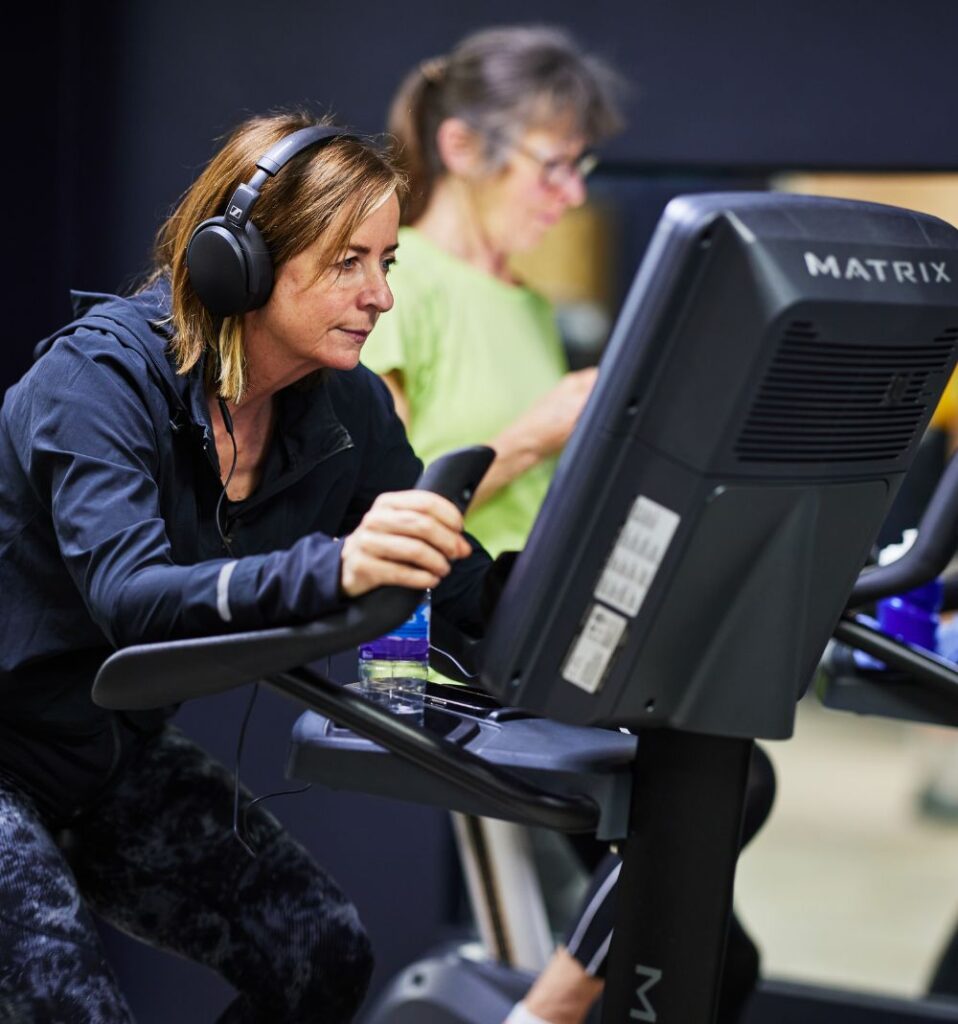 woman on a matrix stationary training bike with virtual screen