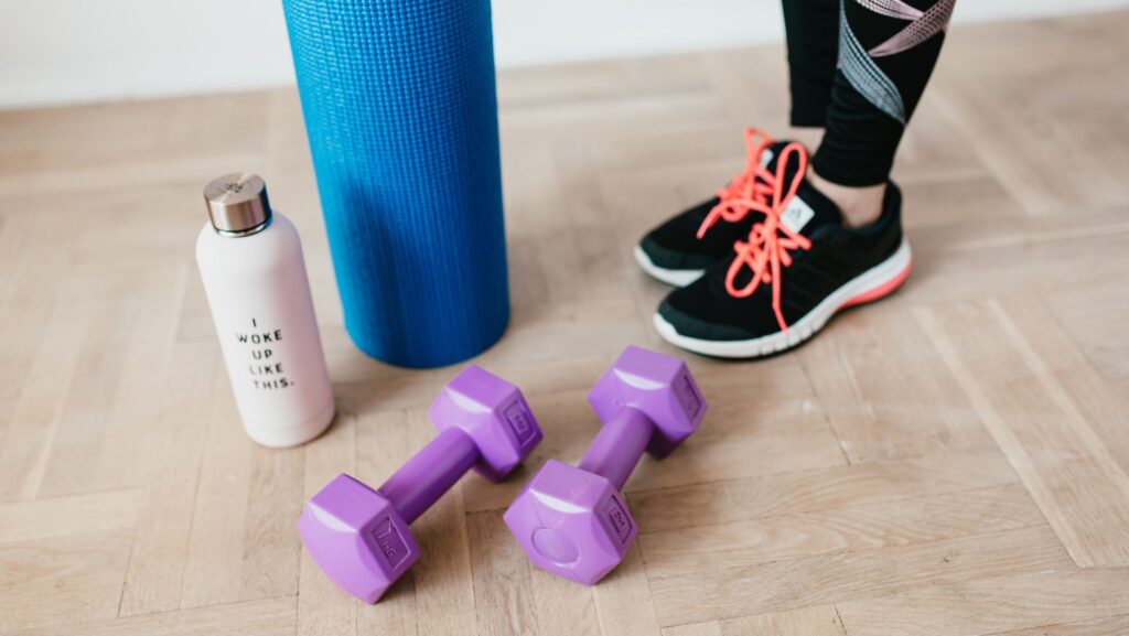 person standing by workout equipment on wood floor