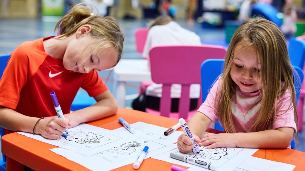 kids drawing at an arts and crafts table