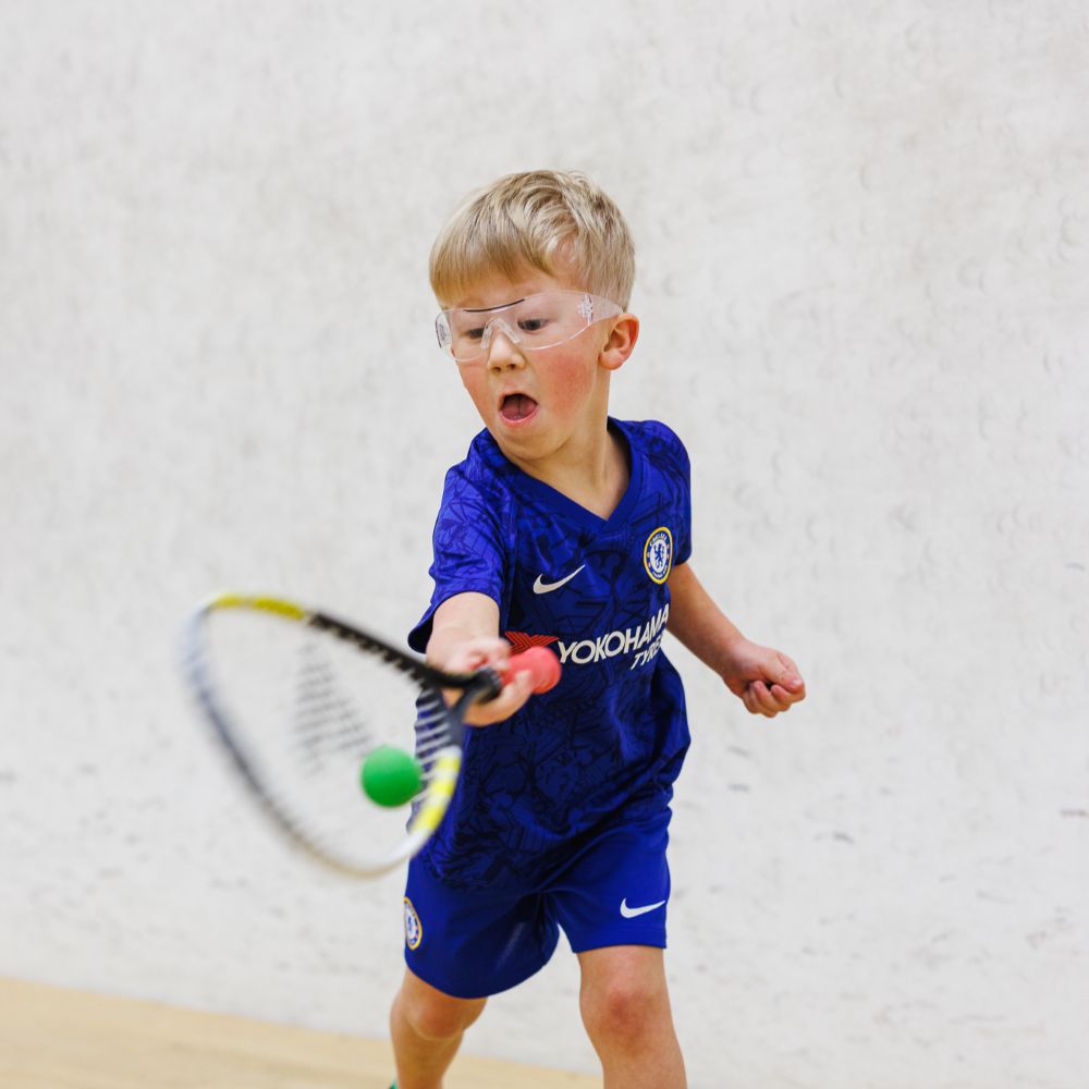 young boy playing squash