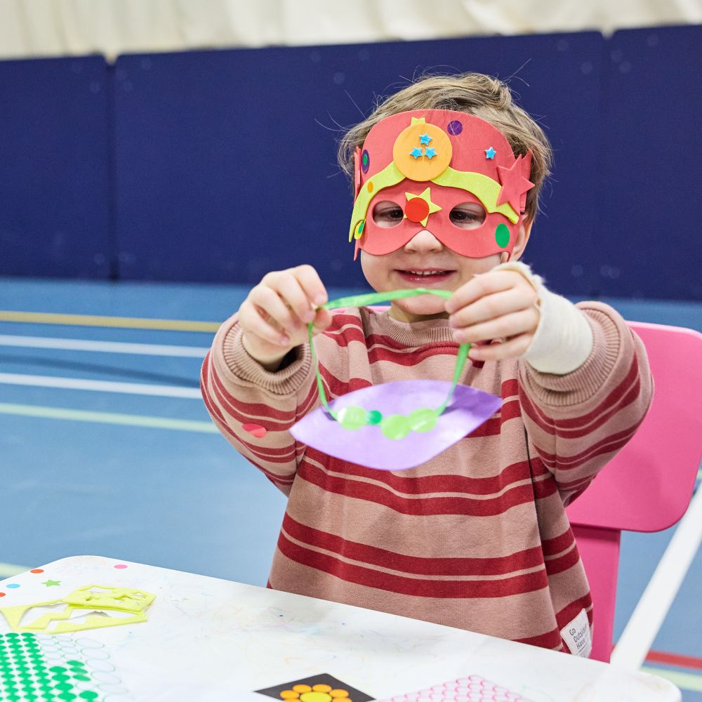 child making fun mask in arts and crafts