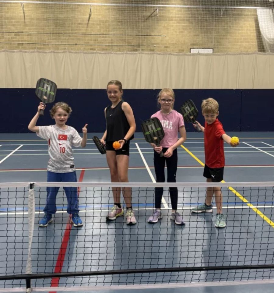junior children with pickleball rackets in an indoor pickleball court at bluecoat sports