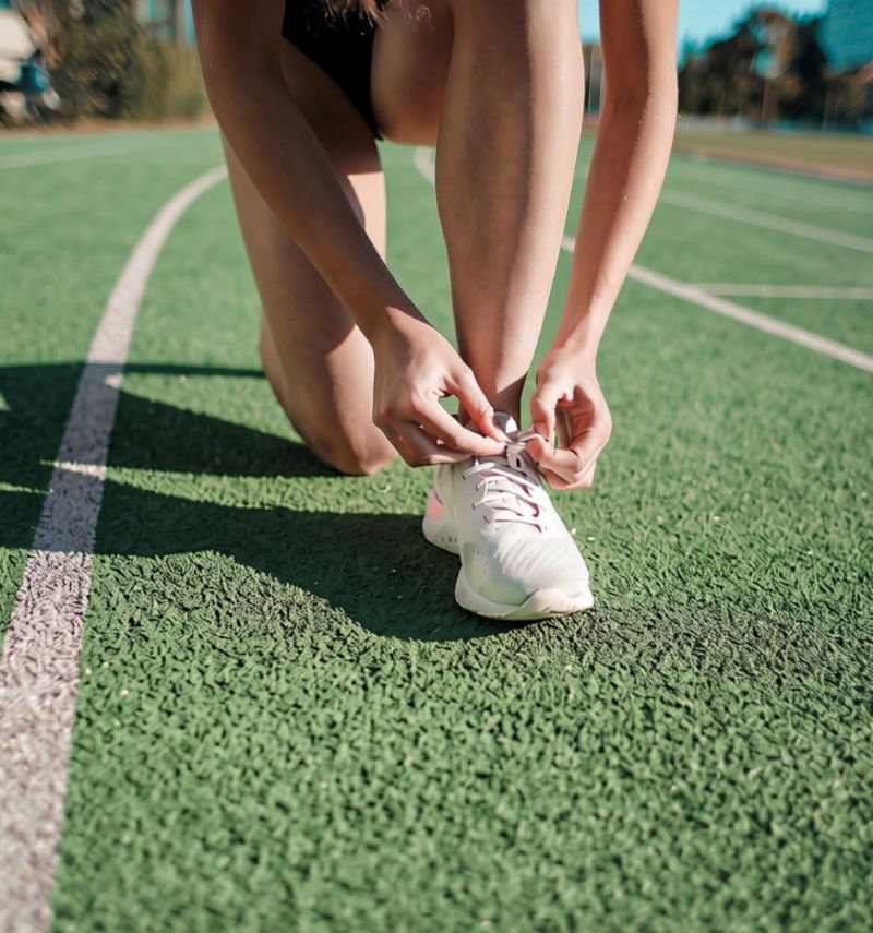 person tying shoes on running track