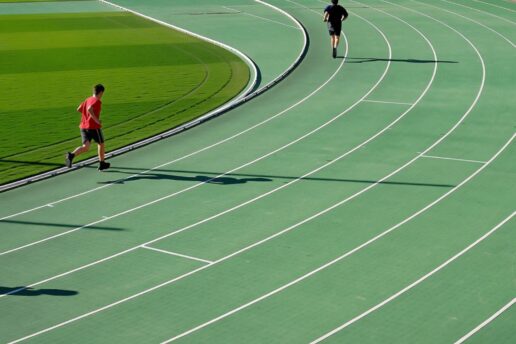 two people running on a running track