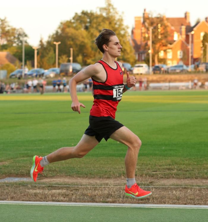 male running with long strides on athletics track