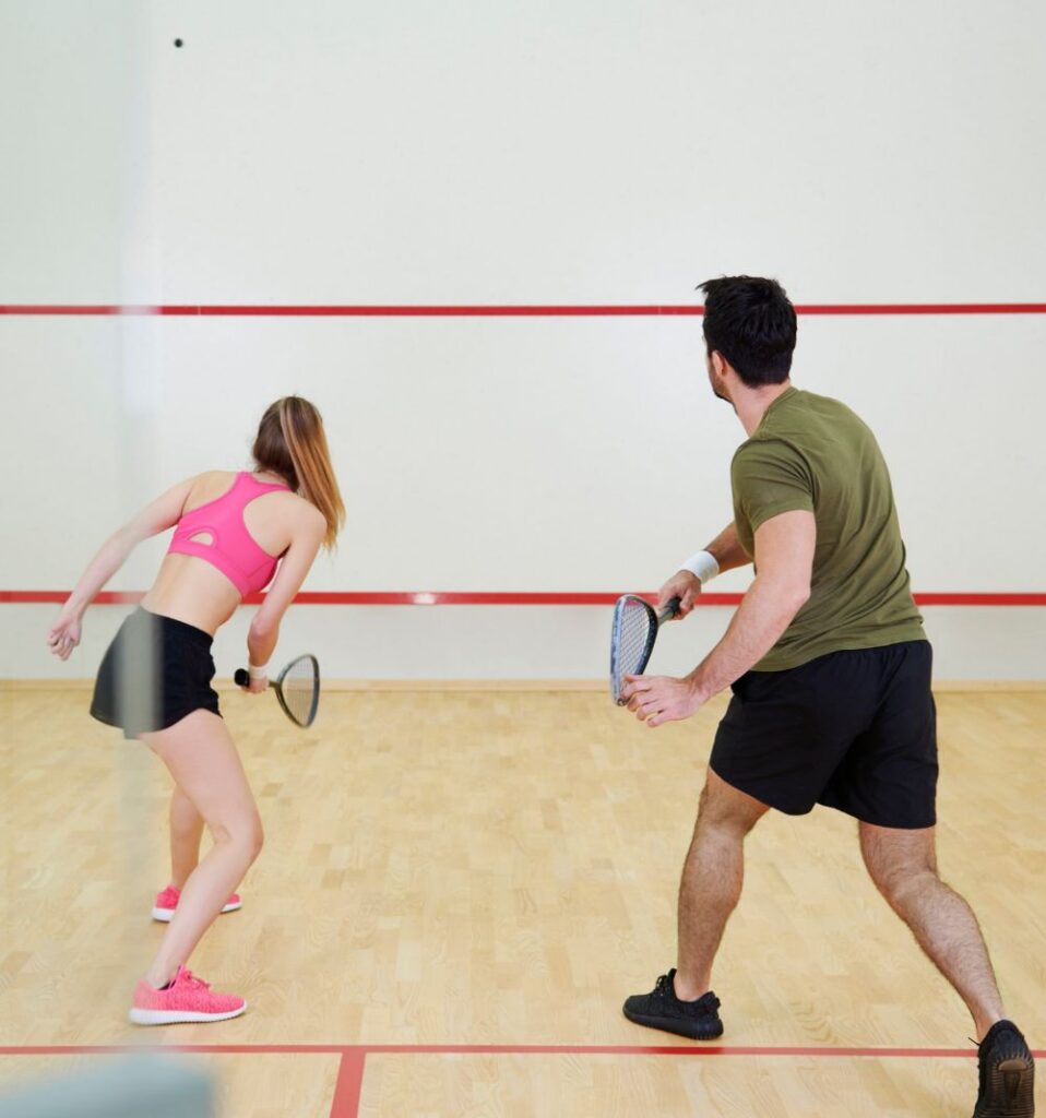 man and woman practicing doubles squash